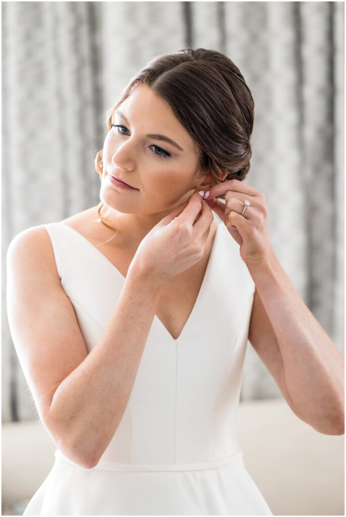Bride puts in her earrings prior to wedding