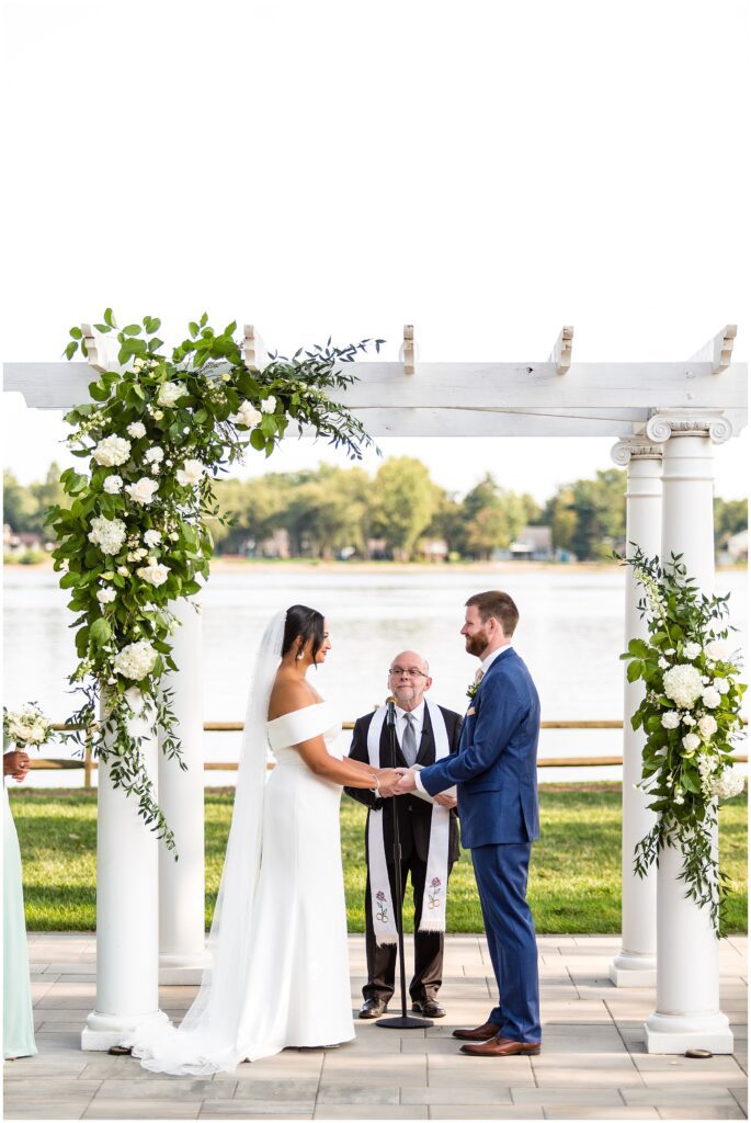 Bride and Groom hold hands at altar during their wedding ceremony