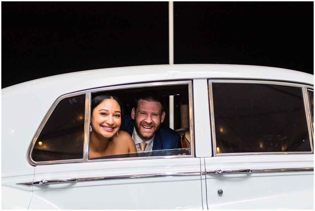 Newlyweds leave wedding reception in a vintage Rolls Royce
