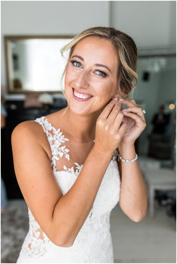Bride puts on her earrings prior to her wedding