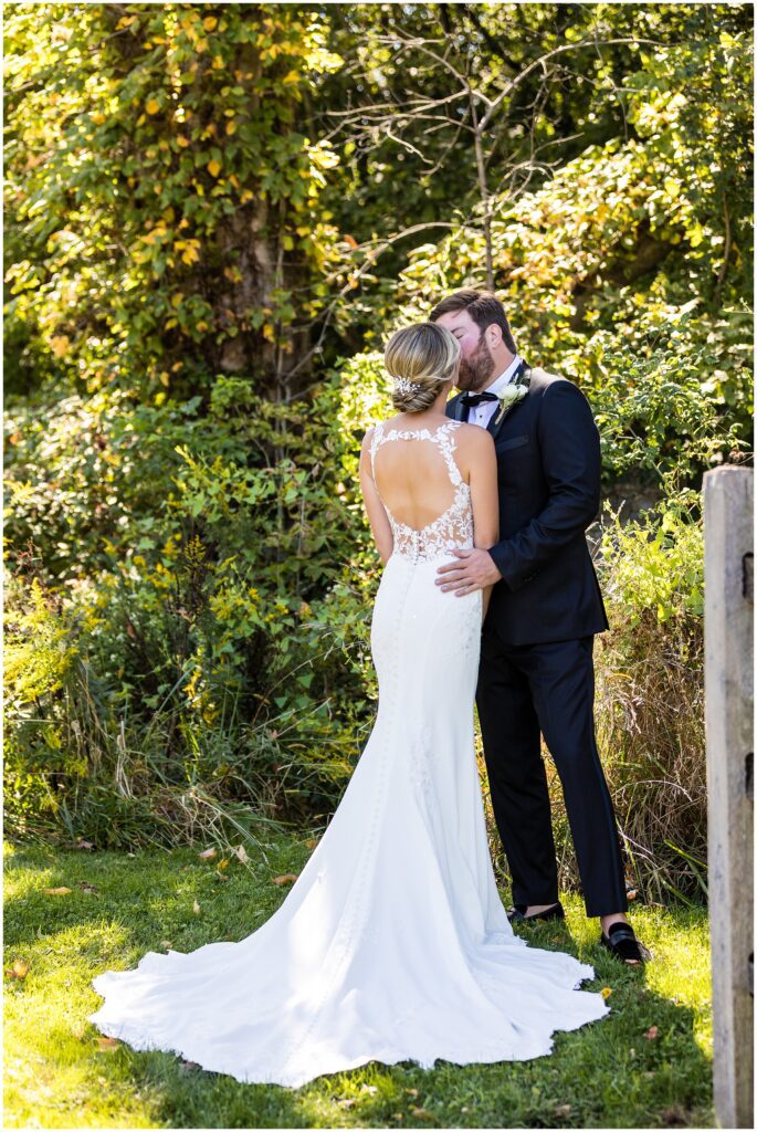 bride and groom have a quick kiss while taking portraits