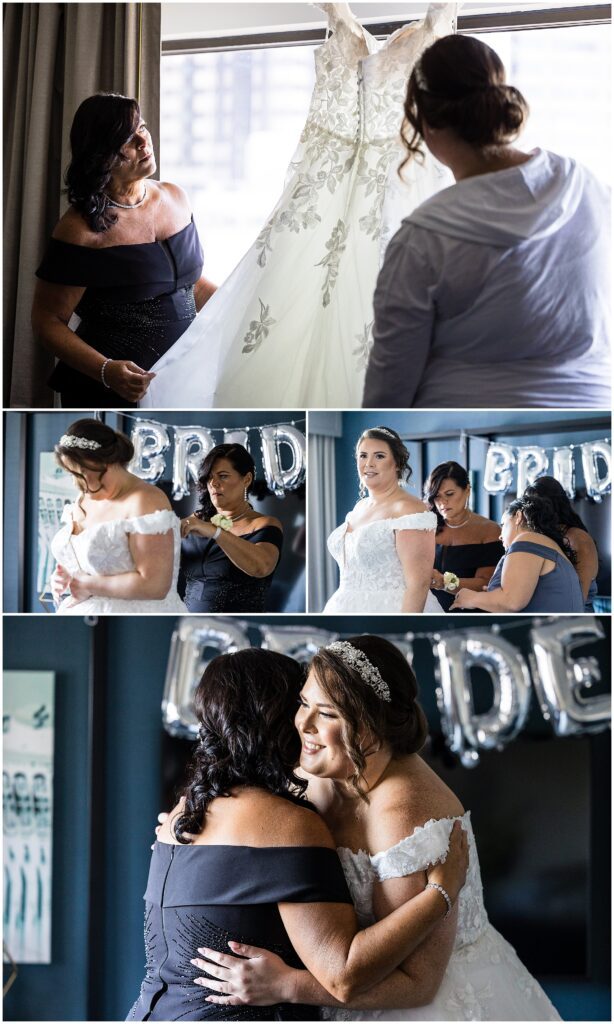Bride is assisted with her wedding dress by wedding party and mom 