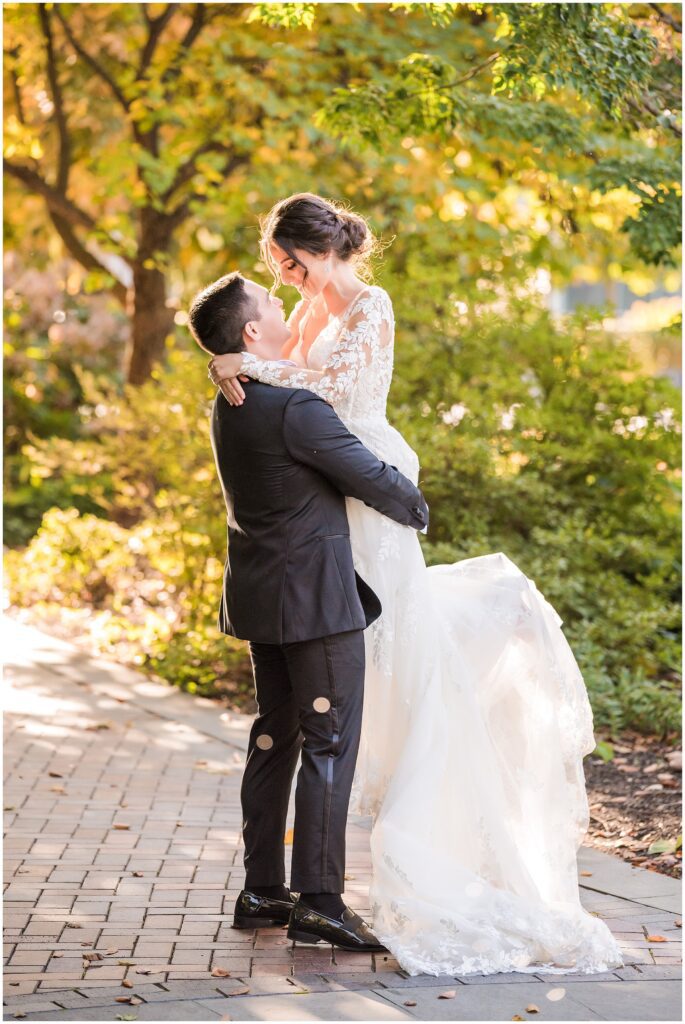 Groom lifts his bride as he hugs her
