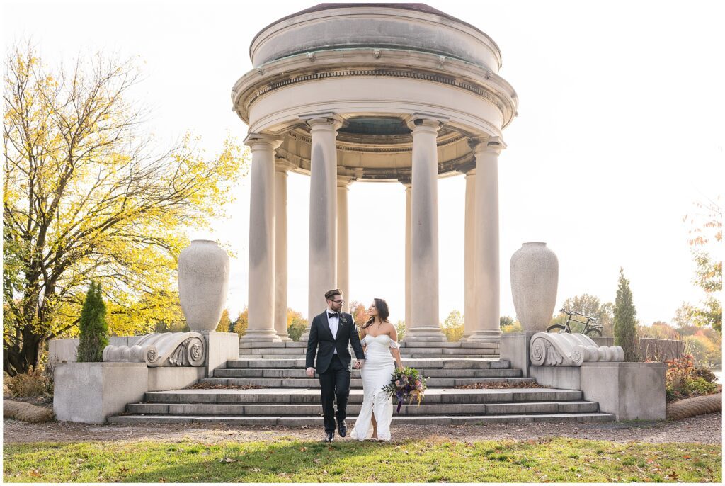 Couple holds hands and smiles at each other while walking away from the pavilion in FDR Park