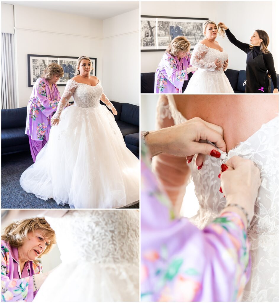 Bride gets her hair adjusted while she is buttoned into her wedding dress that has long lace sleeves and a ball gown skirt with lace details