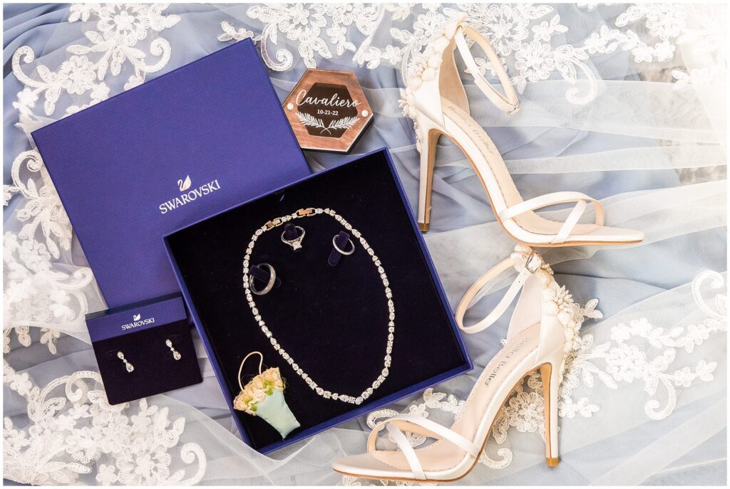 wedding shoes and jewelry styled over bride's detailed lace veil