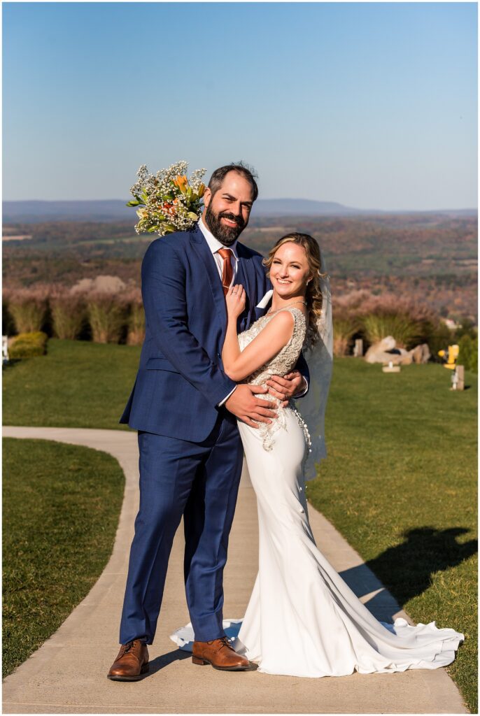 Newlyweds smile for portrait with stunning mountain backdrop