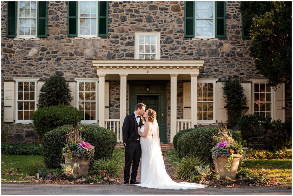 Couple kisses in front of the Inn at Grace Winery