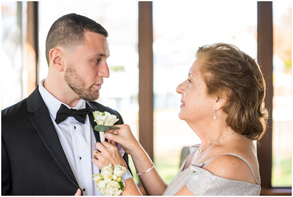Groom's mother pins boutonniere onto her son