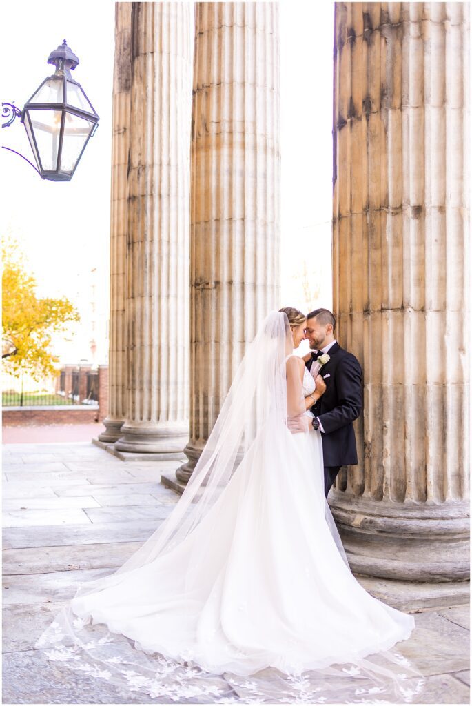 portrait of Bride and Groom on their wedding day near column at historic First Bank