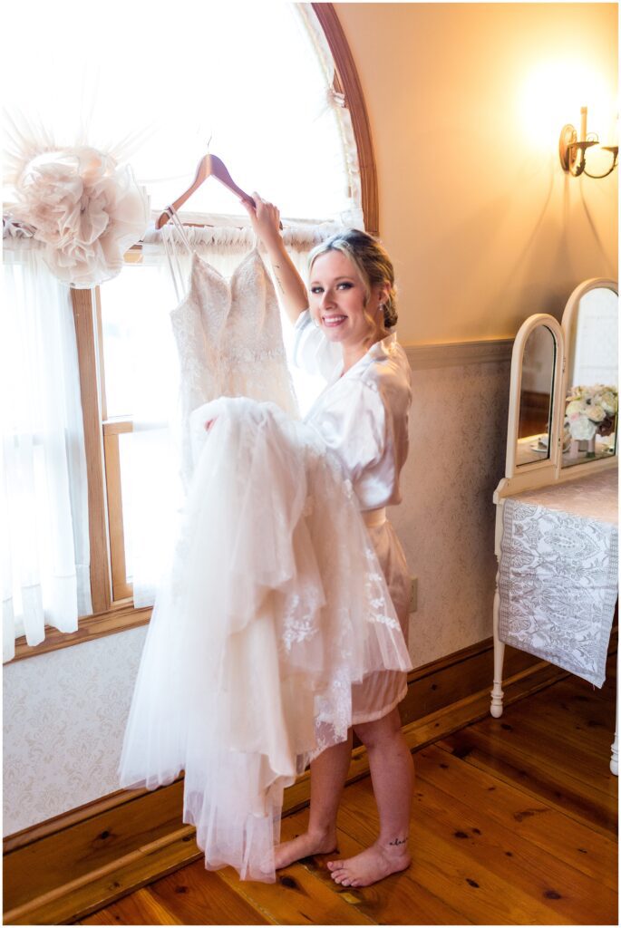bride holds her wedding dress on hanger