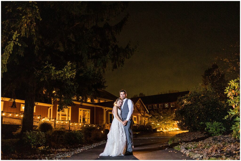 Nighttime portrait of newlyweds outside of the barn ballroom at Meredith Manor