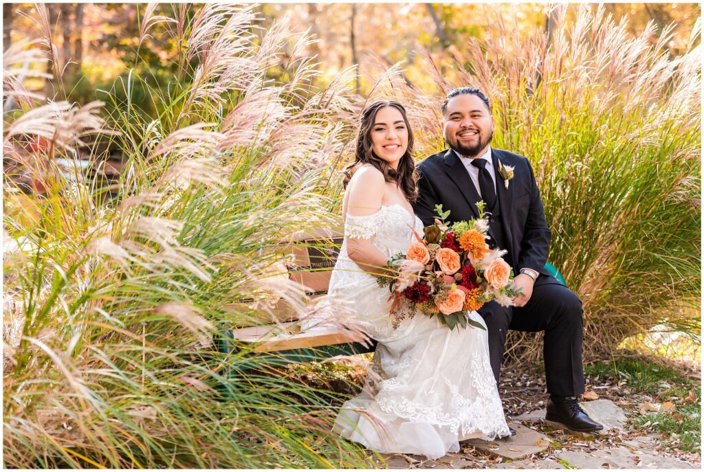 newlyweds sit on a bench 