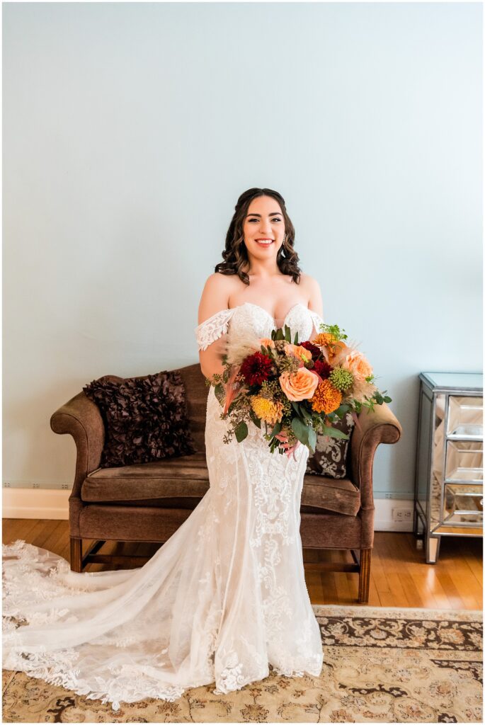 Bride holds her colorful fall bridal bouquet
