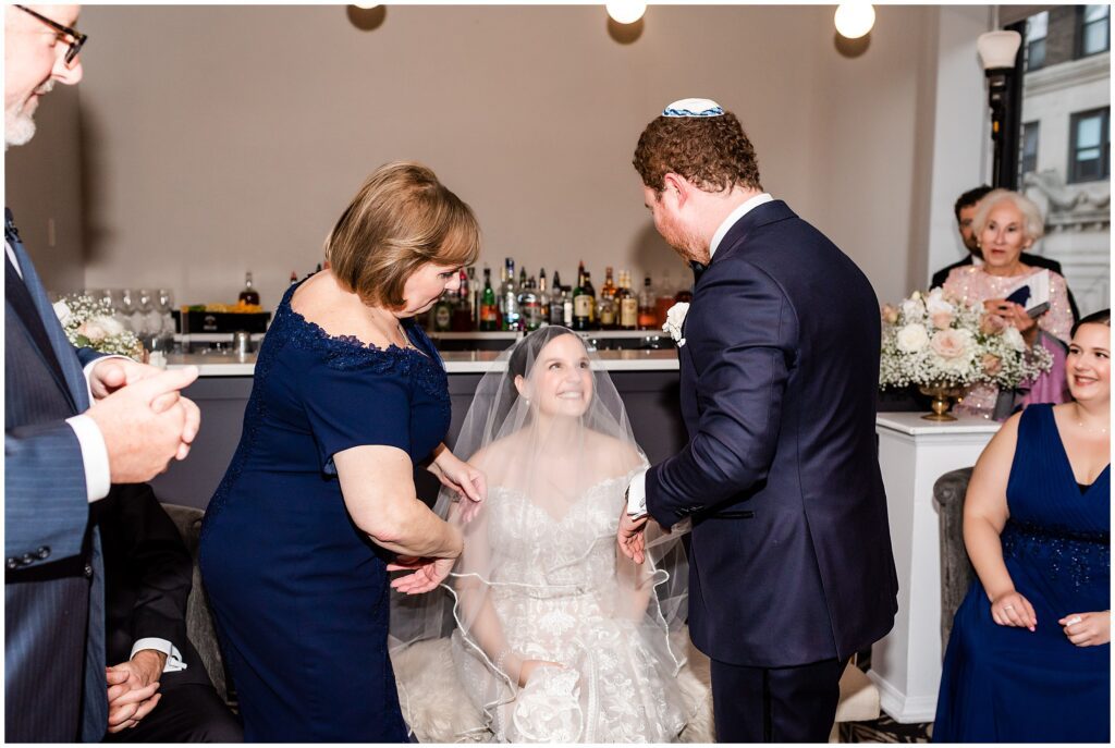 Groom veils bride after signing of Ketubah before their wedding ceremony
