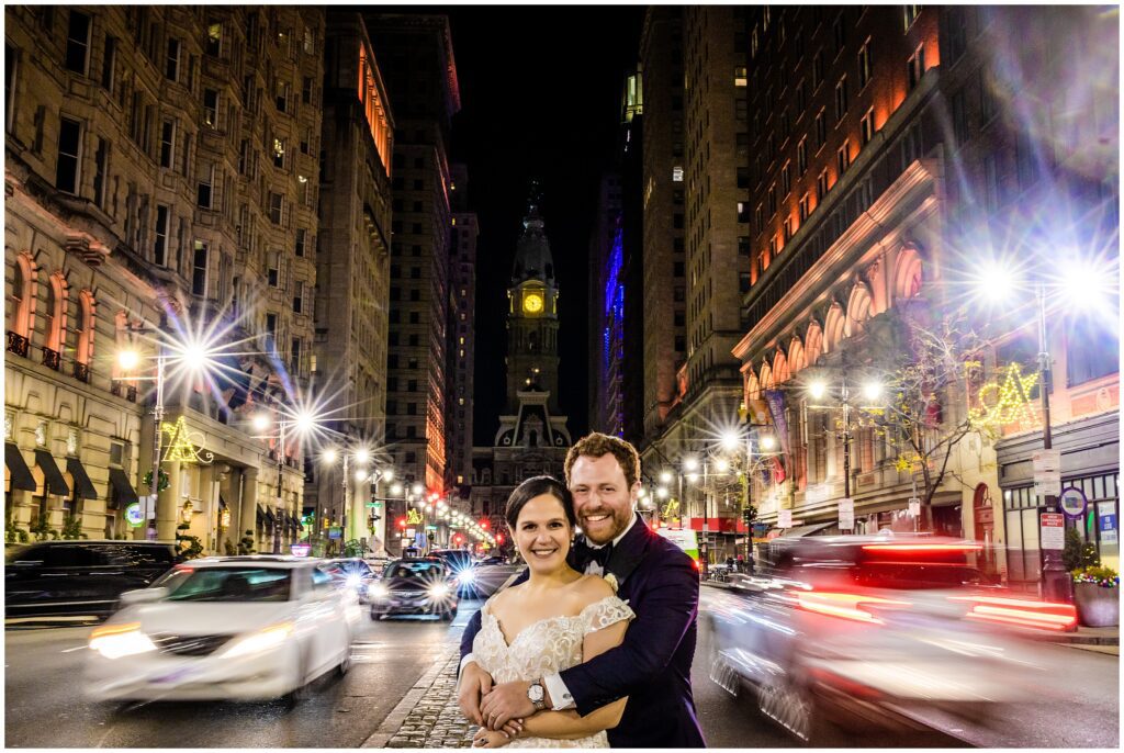 newlyweds on Philadelphia's Broad St at night - with City Hall behind them