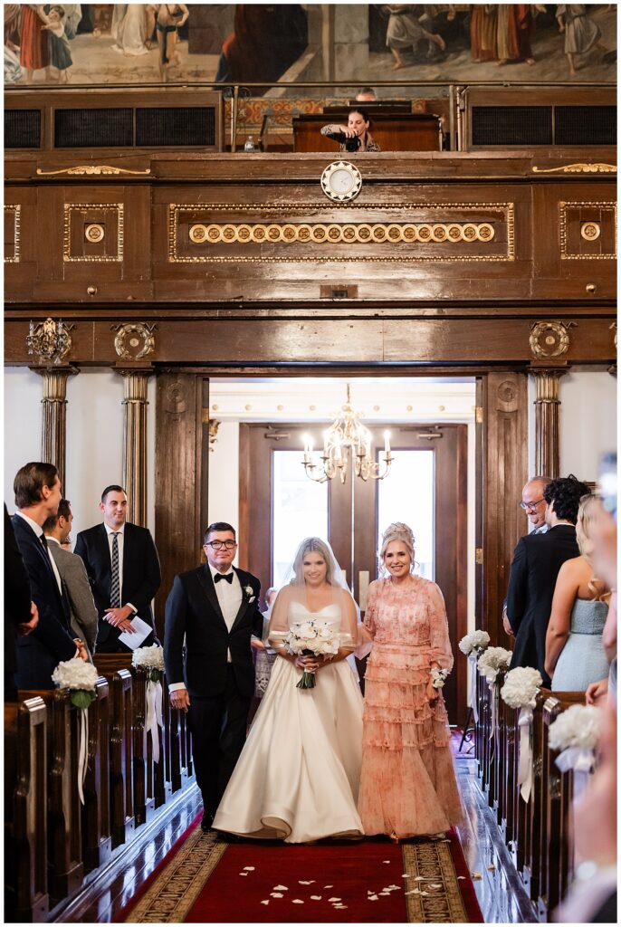 Parents of the bride walking bride down the aisle during Greek Orthodox Church wedding ceremony | Ashley Gerrity Photography