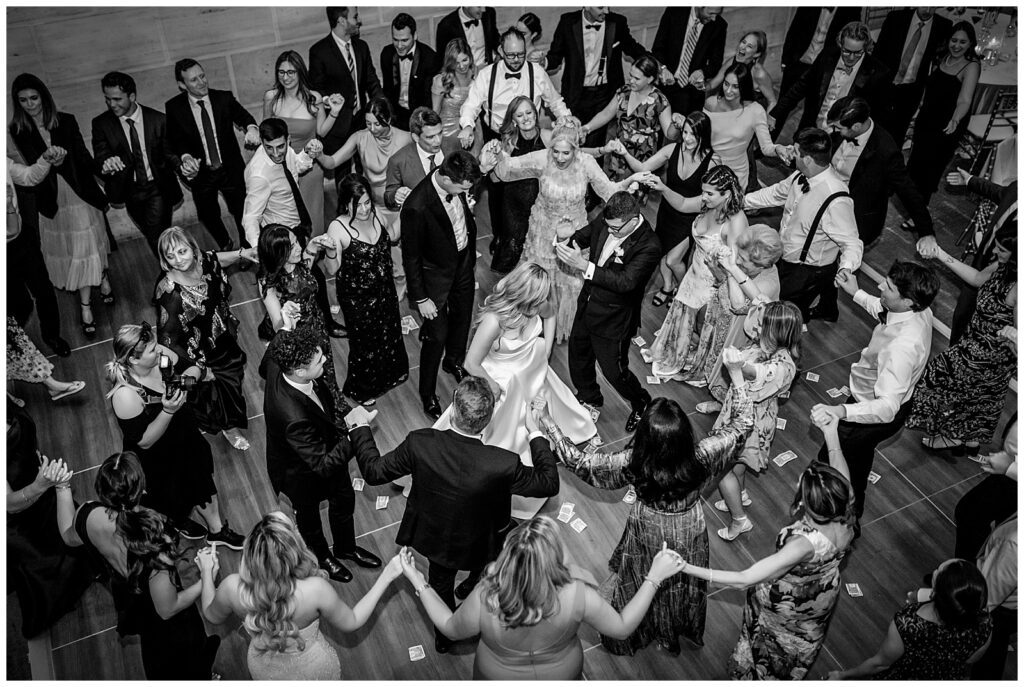 Black and white portrait of bride and her father in the center of a Greek dance circle at Union Trust wedding ceremony | Ashley Gerrity Photography