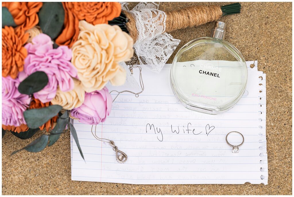 Bridal details with Chanel perfume, wooden flower bouquet, necklace, engagement ring, and letter to bride from the groom | Ashley Gerrity Photography