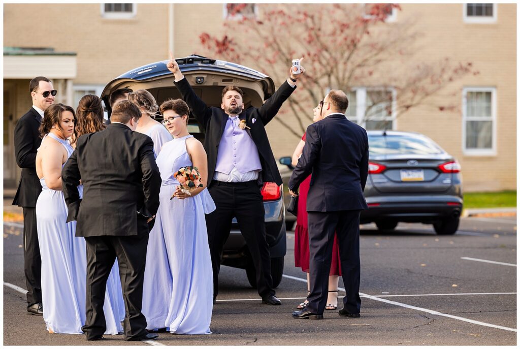 Groomsmen cheering in parking lot of church before wedding ceremony at St. Cecilia | Ashley Gerrity Photography