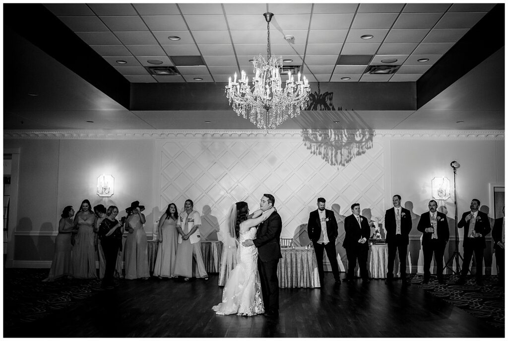 Black and white portrait of bride and groom first dance with wedding party watching during Philadelphia Ballroom wedding reception | Ashley Gerrity Photography