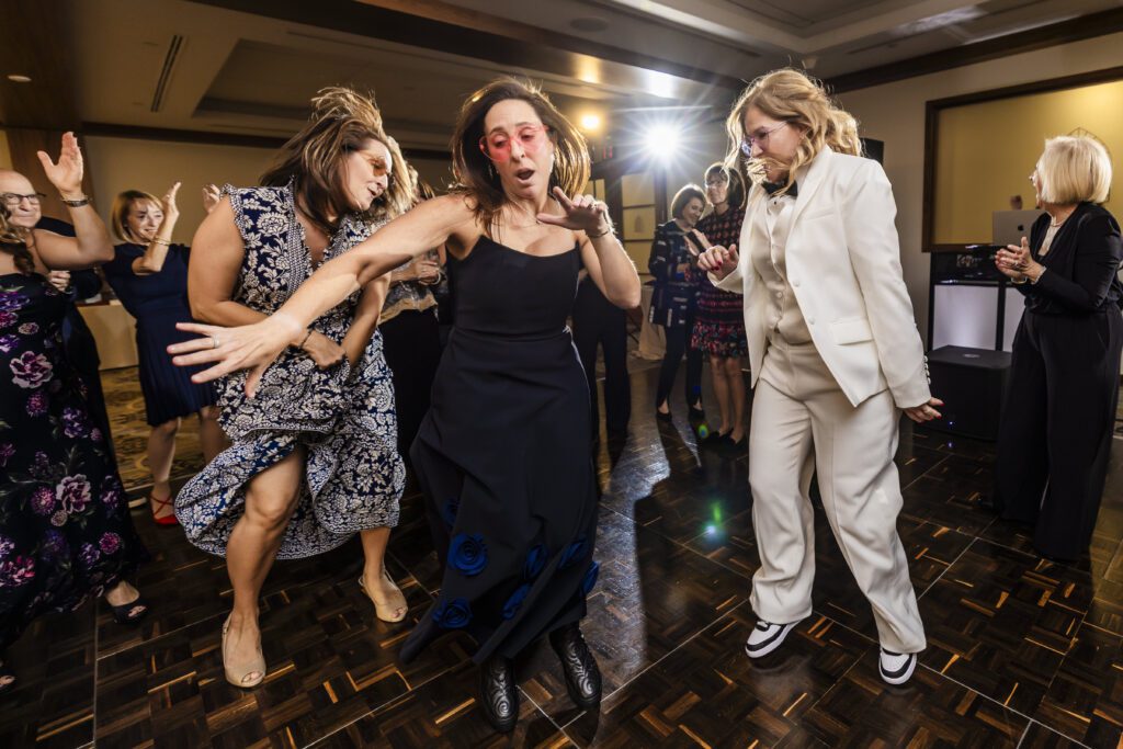 Wedding guests dance together with colorful sunglasses
